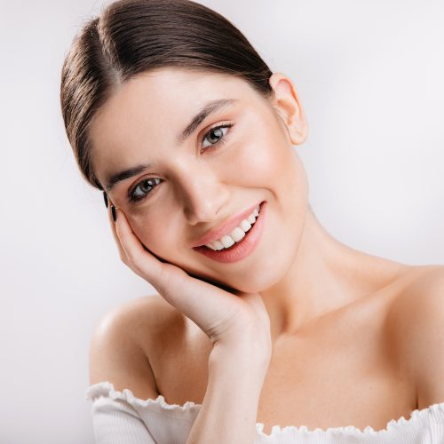 portrait-smiling-girl-with-healthy-skin-cute-dark-haired-woman-white-wall