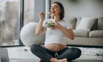 young-pregnant-woman-eating-salad-home