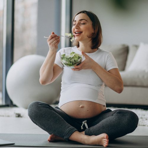 young-pregnant-woman-eating-salad-home